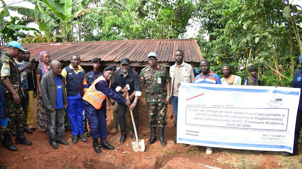 Un groupe pose pour une photo commémorative à l'extérieur.
