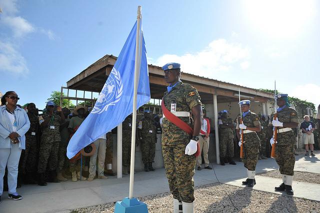 A military officer stands near the UN flag